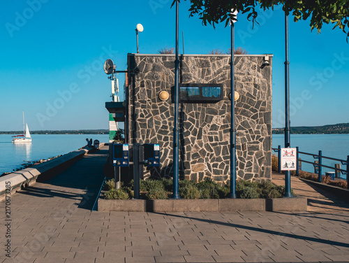 Plakat Stone utility building beside a waterfront promenade