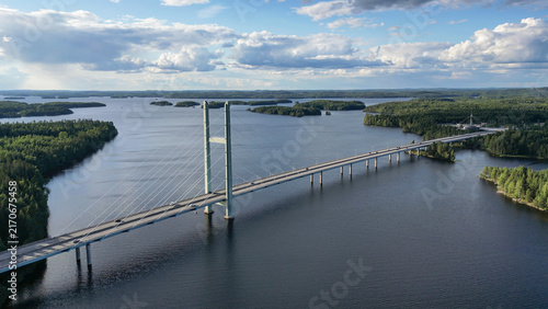 Aerial view of Tähtiniemi Bridge crossing Lake Ruotsalainen in Heinola, Finland. The cable-stayed  highway bridge stretches across a scenic Finnish lake landscape surrounded by forested islands