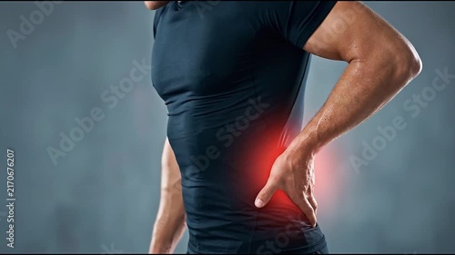 Man Lower Back Pain Discomfort and Muscle Strain Medical Health Portrait Showing Painful Area with Hand Support and Red Glow Against Dark Studio Background