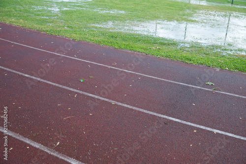 Athletics track after heavy rain with flooded grass, making outdoor training difficult in autumn