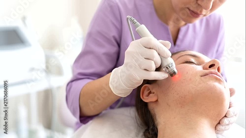 cosmetologist in blue gloves performing a botox, mesotherapy, dermastamp, laser hair removal, facial cleansing, and anti-age procedure on a female client in a modern aesthetic clini