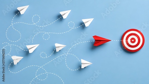 Red paper airplane leading white paper airplanes towards red target center representing leadership vision focus and strategic success in business growth concept.