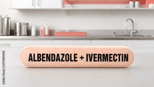A peach colored veterinary bolus with text label sits on a white surface in kitchen with albendazole ivermectin printed inside kitchen setting close with setting