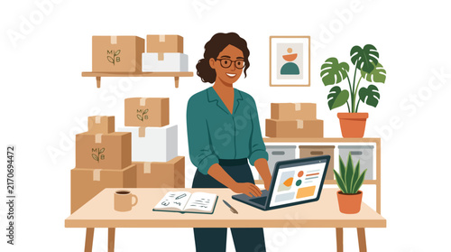 A smiling female entrepreneur works on her laptop at a desk surrounded by cardboard boxes in her cozy home office setup.