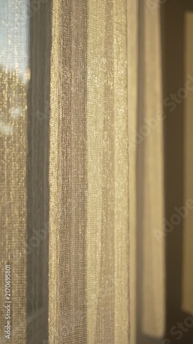 Sheer curtains softly illuminated by sunlight, creating a warm ambiance in a cozy indoor setting with visible textures and patterns enhancing the atmosphere