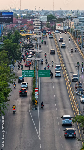 Fotografie Vehicles and motorcycles travel on an elevated road in the urban area of Banjarm