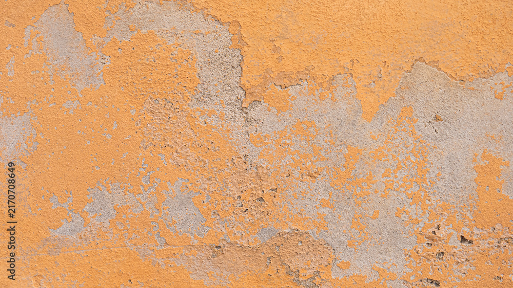 Fototapeta premium A concrete wall with faded yellow paint