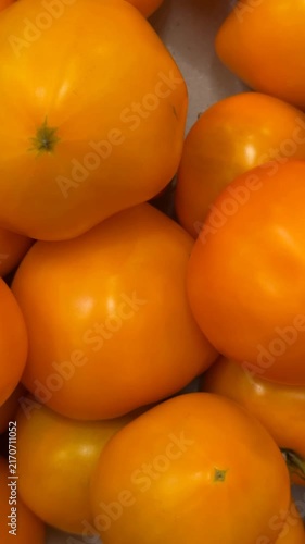Orange tomatoes closely stacked forming a textured background ideal for food and produce themes