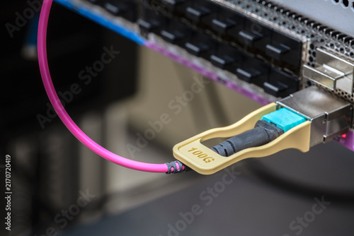 Konstfotografi Close up of a 100Gbit network transceiver with a patch cable inserted into a swi