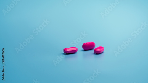 Foto Pink tablets on blue background