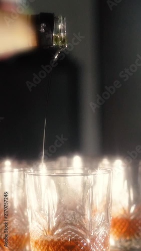 elegant man businessman millionaire in jacket and suit pours expensive whiskey into glass. Exquisite brown alcoholic drink for relaxation and enjoyment. Groom man billionaire