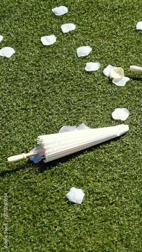 Stylish white vintage umbrellas provide shade from the hot, bright sun on a sunny summer day. Wedding ceremony for the bride and groom.