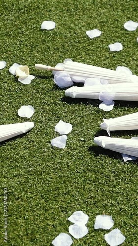 Stylish white vintage umbrellas provide shade from the hot, bright sun on a sunny summer day. Wedding ceremony for the bride and groom.