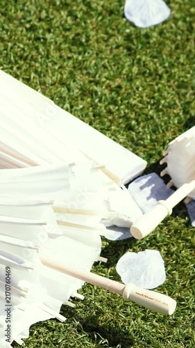 Stylish white vintage umbrellas provide shade from the hot, bright sun on a sunny summer day. Wedding ceremony for the bride and groom.