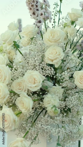 wedding arch of white rose flowers on the river bank before the wedding ceremony of the bride and groom, festive romantic decor