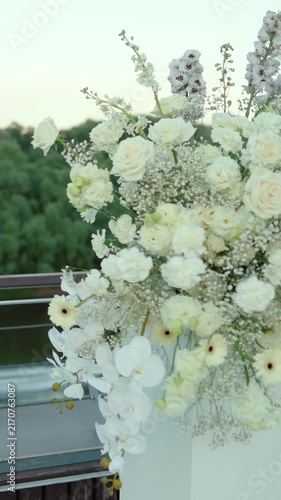wedding arch of white rose flowers on the river bank before the wedding ceremony of the bride and groom, festive romantic decor