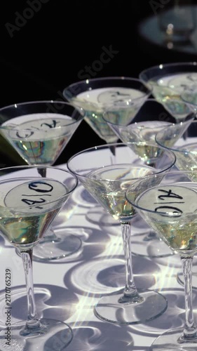 Glasses of sparkling wine shimmer in the sun outside during a festive event. Champagne is an alcoholic beverage at a banquet in an upscale restaurant.