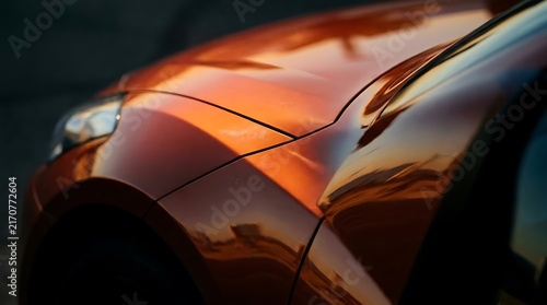 Close up detail of orange metallic car body.