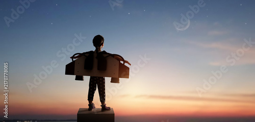 Bild auf Leinwand Dream Big: Child with Homemade Jetpack Gazing at Crescent Moon Under Starry Sky