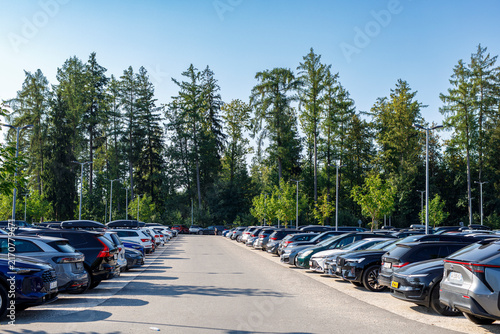 Quadro su tela A large outdoor parking lot filled with rows of modern cars under a clear blue s