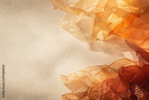 Warm, translucent plastic folds drift across a soft, textured wall