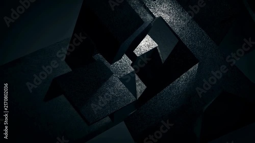 Dark metallic geometric blocks rotate slowly with shifting angles in a dimly lit studio environment. Animated background combines subtle reflections with layered depth.