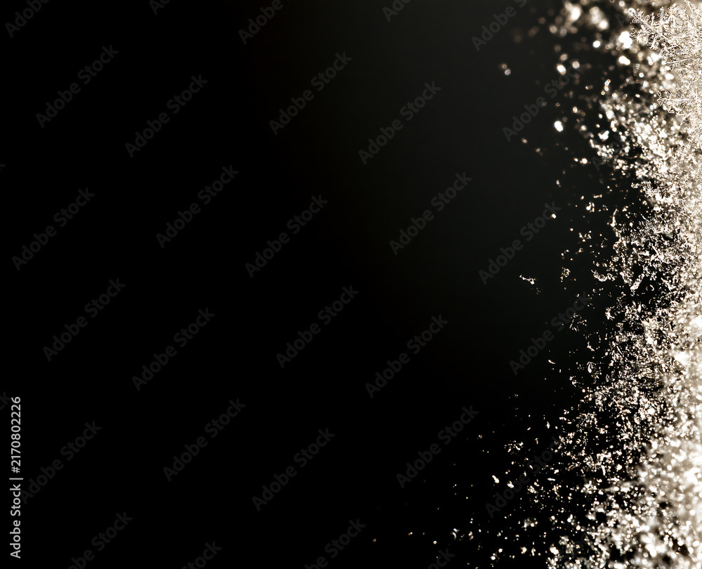 Fototapeta premium Vertical macro image of winter frost and snow crystals on black background. Ice texture border on right side. Winter freeze texture ideal for holiday season overlays