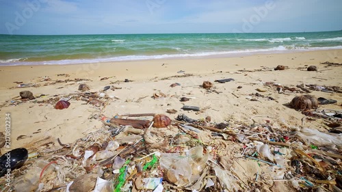 Plastic Waste Found On Sandy Beach. Plastic Bottles, Bags, And Other Debris Are Present Along The Shoreline, Reflecting The Ongoing Impact Of Human Activity On Coastal And Marine Environments