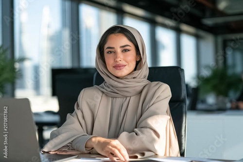 Confident Emirati businesswoman wearing elegant hijab in a modern office, professional leadership and women's empowerment concept