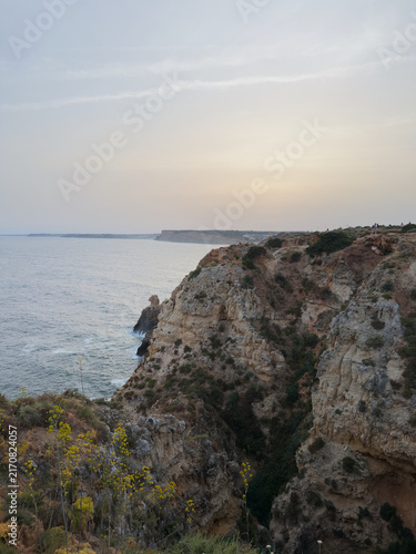 Dramatic coastal cliffs overlooking calm sea at sunset