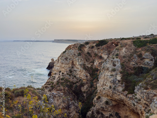 Rugged coastal cliffs overlooking calm sea at sunset