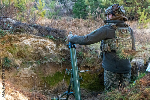 Принти на полотні Ukrainian soldier adjusting mortar sight in a trench