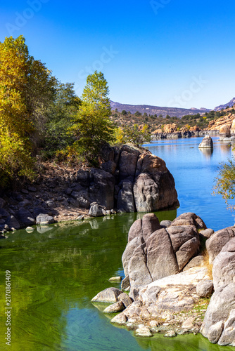 Watson Lake in Prescott Arizona water view showing green algae and bounders in a shallow area