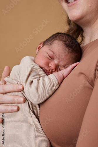Tender Newborn Sleeping on Mother's Chest in Interracial Family Portrait, Multiracial Bonding Moment