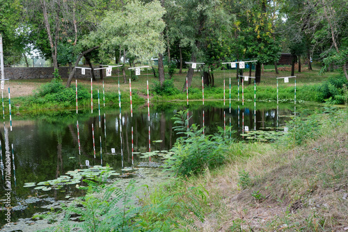 Outdoor kayak slalom training course on a calm river in a green park