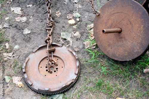Brutal homemade steel flywheel and rusty iron weights on the ground