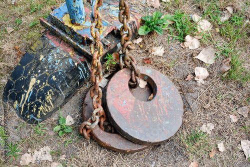 Brutal heavy chains and iron weights on ground of outdoor backyard gym