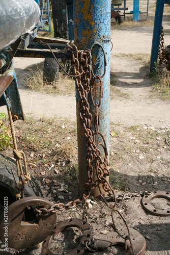Heavy rusty steel chains hanging on homemade gym equipment