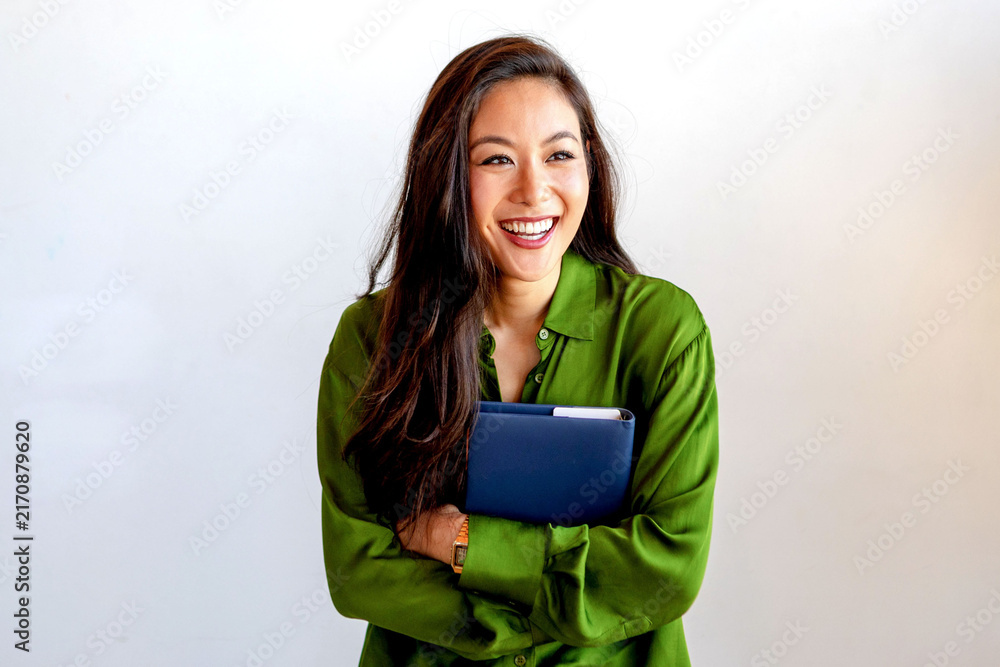 Obraz premium Confident woman holding notebook smiling.