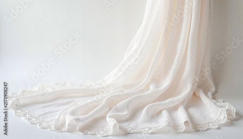 White lace-trimmed fabric draped elegantly on a neutral background

