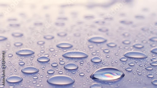 Clear water droplets resting upon smooth reflective surface macro photography capturing calming lilac light atmosphere