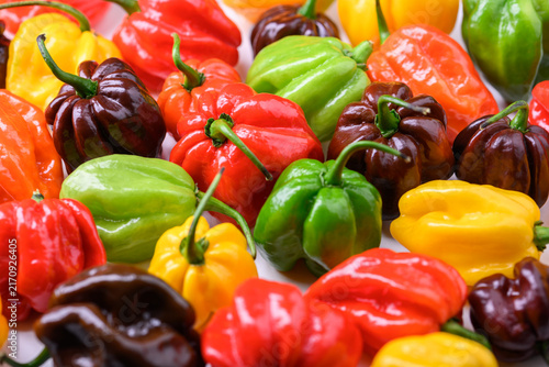 Картината върху платно Assorted habanero peppers in different colors tightly packed, top view