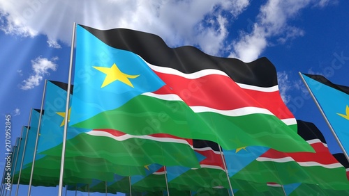 Multiple South Sudan flags waving on blue sky