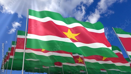 Multiple Suriname flags waving on blue sky