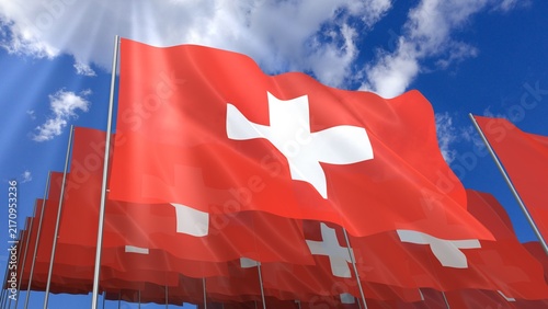 Multiple Switzerland flags waving on blue sky