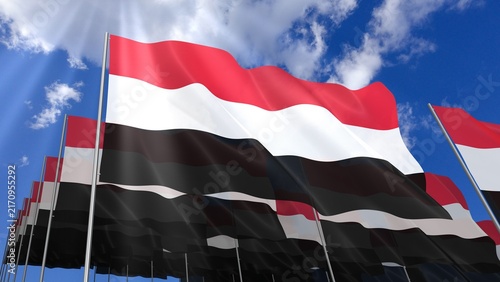 Multiple Yemen flags waving on blue sky