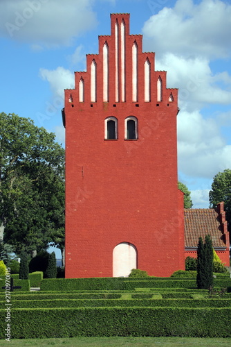 Torre campanaria rossa di chiesa tradizionale danese con timpano a gradoni