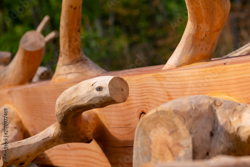Wooden sculpture made from natural branches sits in a garden under sunlight in autumn