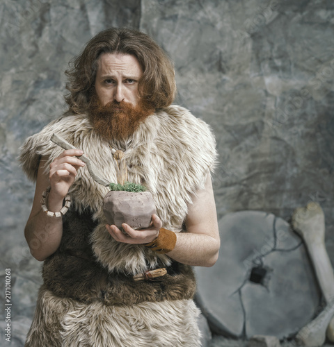 Canvastavla Disappointed prehistoric man dieting and eating a salad