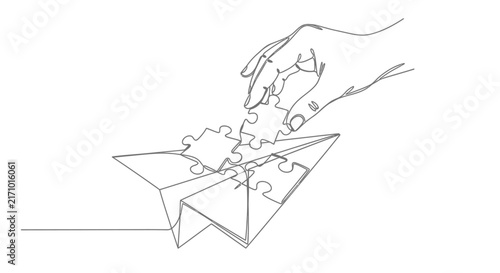 Hand placing final piece into paper airplane puzzle silhouette jigsaw